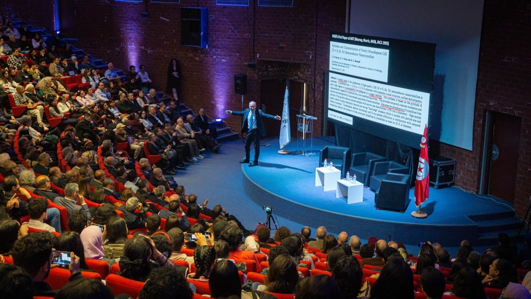 Large conference auditorium filled with business audience